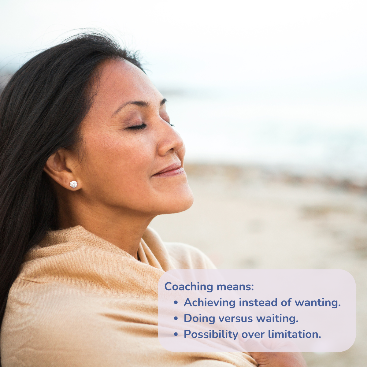 Woman on the beach with her eyes closed, smiling.